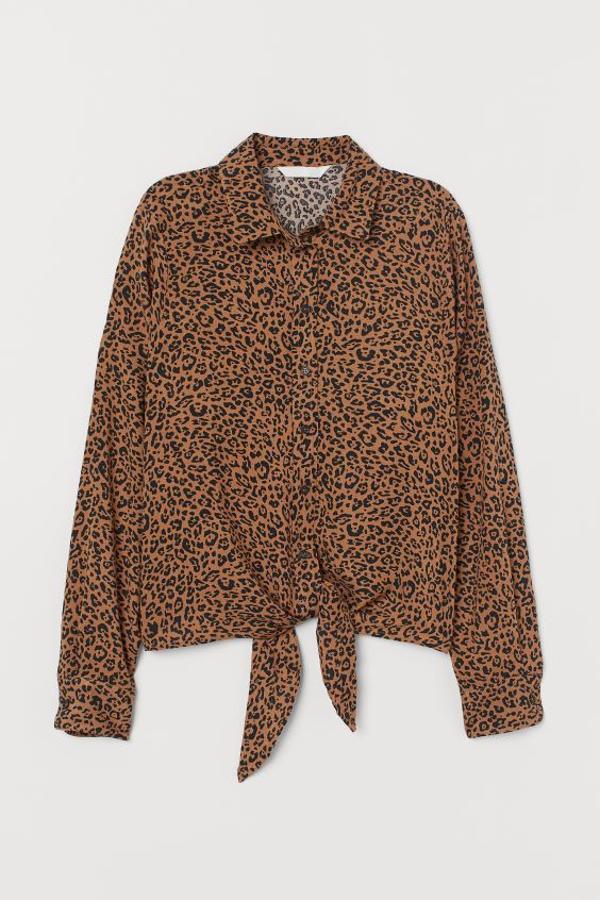 En beige oscuro, con cuello clásico, mangas largas y bajo con lazada, esta camisa de H&M tiene un precio de 19,99 euros y podemos encontrarla entre las tallas 32 y 46, menos en la 44.