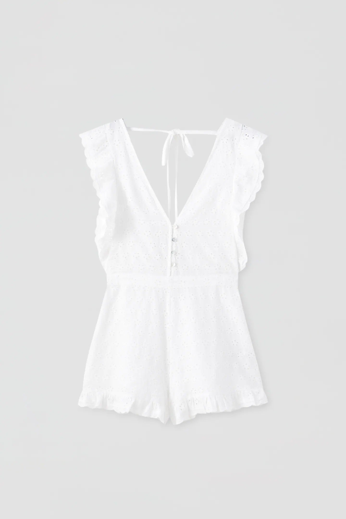 Para looks de otro nivel, sal de los básicos con este mono blanco de bordado suizo. ¡Sienta como un guante! (25,99 euros).