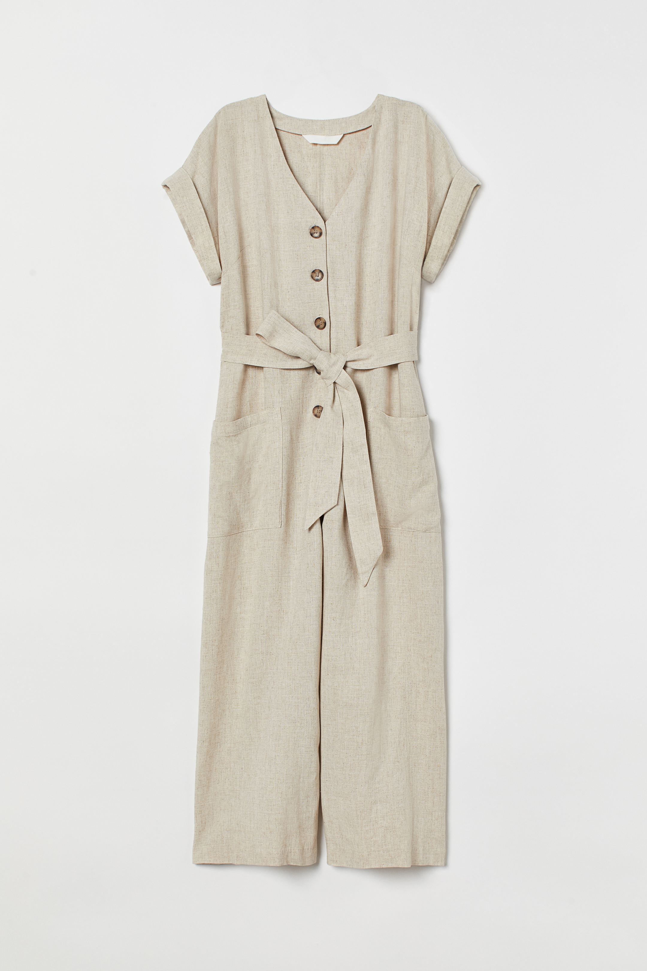 Mono largo en color beige de lino, con cierre de botones, escote a pico y cinturón para resaltar la figura. (39,99 euros en H&M).