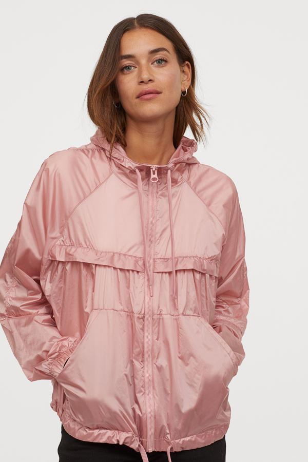 De venta exclusiva en la web de H&M, esta chaqueta cortavientos en color rosa confeccionada en nailon fresco viene con cremallera, capucha con cordón de ajuste y bolsillos al bies. Con mangas raglán largas con elástico revestido en los puños y cordón de ajuste en el bajo tiene un precio de 39,99 euros y podemos encontrarla entre las tallas XS y XXL.