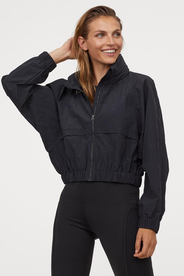 En H&M hemos encontrado esta chaqueta corta en tejido repelente al agua con cuello elevado y cremallera oculta con capucha plegable en el interior. Con bolsillos delanteros, mangas raglán y elástico revestido en puños y bajo, tiene un precio de 39,99 euros y está disponible entre las tallas XS y XL, pero solo se vende en la web de la firma.