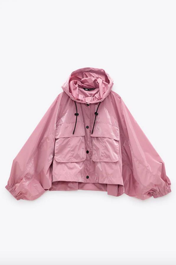 Esta original propuesta de Zara es una chaqueta corta de cuello subido con capucha ajustable con cordones. Con manga larga acabada en puño elástico y bolsillos de plastrón con solapa en delantero viene en color rosa con efecto brillo y tiene cierre frontal con cremallera combinada a contraste. Cuesta 29,95 euros y está disponible entre las tallas XS y XL.