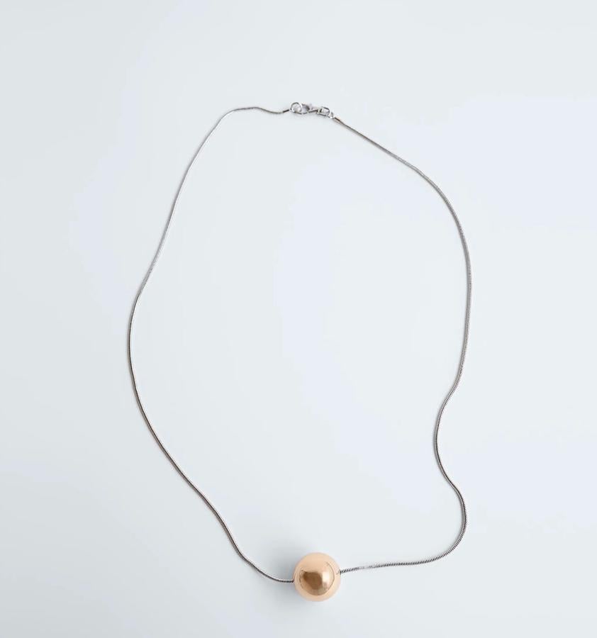 Una bola solitaria cuelga de una cadena a medio escote. Cuesta 9,95 euros.