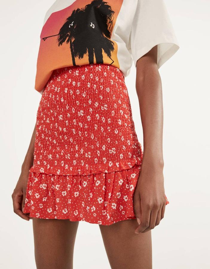Por 15,99 euros en Bershka hemos encontrado esta bonita falda mini en color rojo con diseño de goma canilla y estampado de flores en color blanco. Está disponible entre las tallas XS y L.
