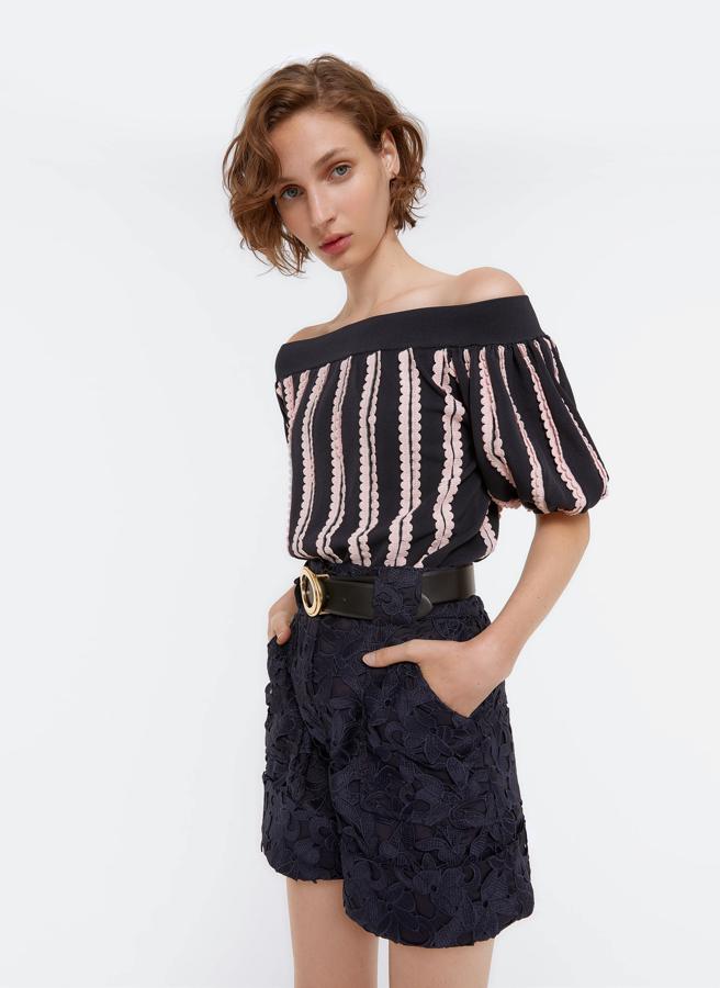 Top de punto bicolor con los hombros al descubierto y manga corta, de Uterqüe (99 €).