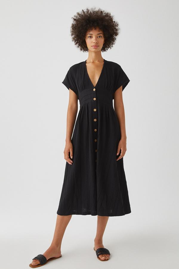 Disponible en color negro o teja, este vestido negro de Pull & Bear cuenta con escote de pico y cierre mediante botones en la parte delantera. Tiene un precio de 22,99 euros.