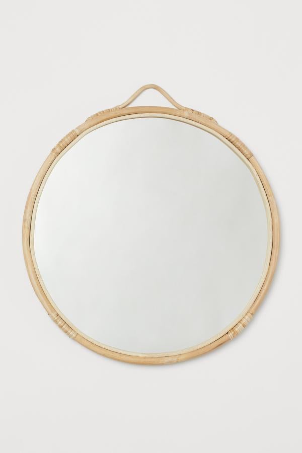 Este espejo, con marco de ratán en color natural hecho a mano, tiene un diámetro aproximado de 42 centímetros. Es de H&M Home y tiene un precio de 49,99 euros.