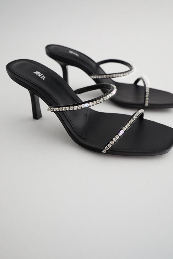 En color negro con tiras de brillos, esta sandalia con tacón de ocho centímetros cuenta con punta cuadrada y tiene un precio de 35,95 euros.