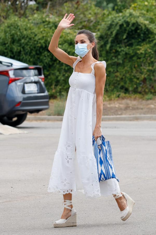 Los Reyes finalizaron su primera semana del verano 2020 en Baleares con una visita oficial a Menorca, donde vimos el que, de momento, es  el vestido más bonito de la reina este verano . Doña Letizia eligió un impecable diseño blanco de organza bordada de la nueva colección de Uterqüe que cuesta 129 euros y ya tiene lista de espera. Como complementos, la reina lo combinó con sus alpargatas color crema de Macarena Shoes y su bolso solidario de Bolsas FQ (lo tiene también en rojo), que busca dar visibilidad a la fibrosis quística.