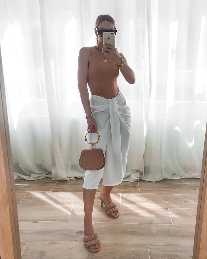 Henar Vicente prefirió no darle color a la falda y la combinó con prendas y complementos nude. Añadió un body sin mangas, unas sandalias tipo mules de doble tira trenzada y un bolso a juego.