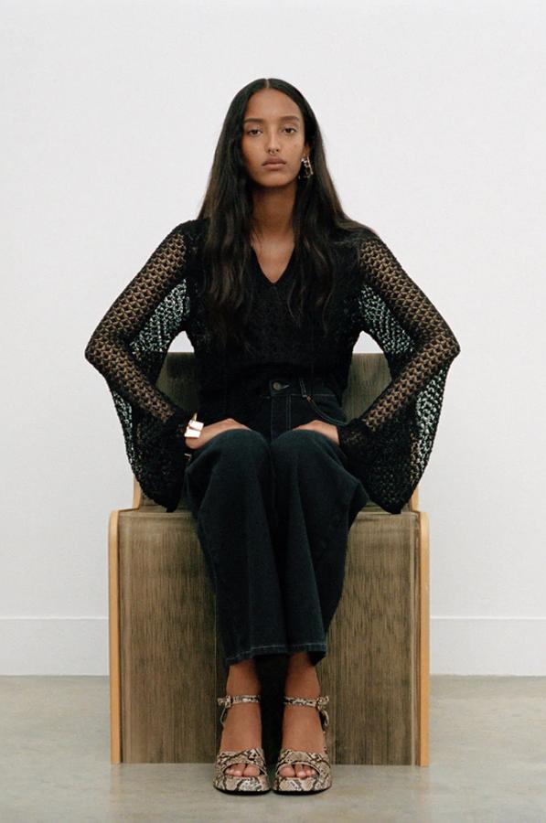 En Zara hemos encontrado esta espectacular blusa en color negro de diseño semitransparente, cuello redondo y manga larga acabada en evasé. Tiene el cierre delantero con cordón y un precio de 22,95 euros. Está disponible en las tallas S, M y L.