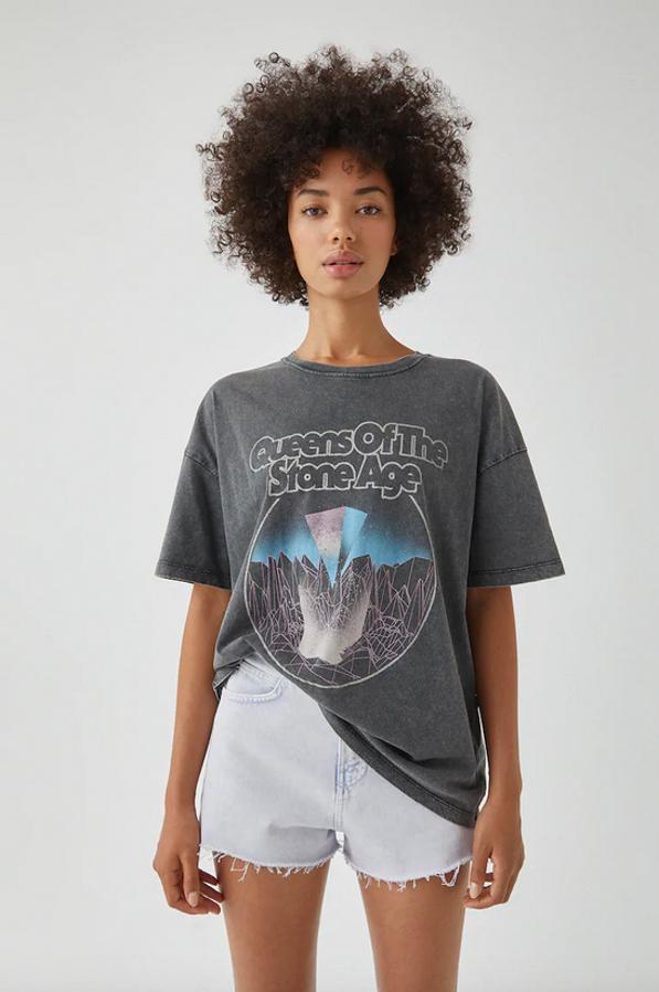 Negro delavado con ilustración a contraste en tonos azules y lilas para esta camiseta dedicada a la banda londinense formada en los noventa Queens of the Stone Age. Con estampación frontal y trasera es de Pull&Bear, cuesta 15,99 euros y está disponible entre las tallas XS y XL.