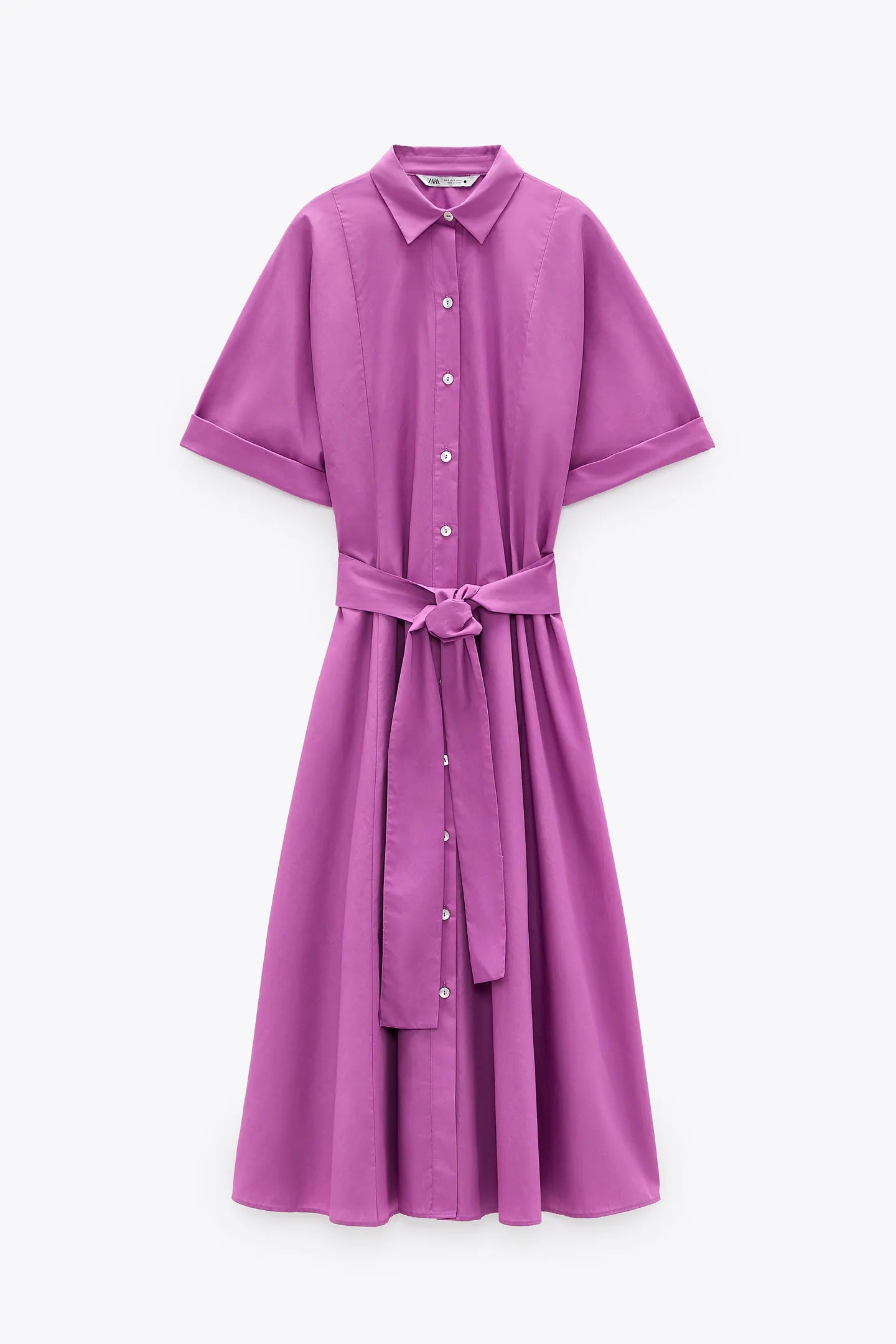 Vestido camisero popelín de largo midi, cuello solapa, manga con vuelta, cinturón y cierre de botones en el tono más ideal para presumir de bronceado, el fucsia. Disponible en todas las tallas y rebajado de 39,95 euros a 19,99 euros en los Special Prices de Zara.