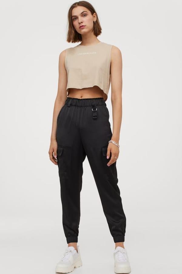 Con elástico revestido y trabillas en la cintura, este pantalón de satén de H&M es de talle alto con bolsillos al bies, bolsillos de pernera con solapa y perneras pitillo largas con elástico revestido en los bajos. En color negro, cuestan 19,99 euros y están disponibles entre las tallas 34 y 50.