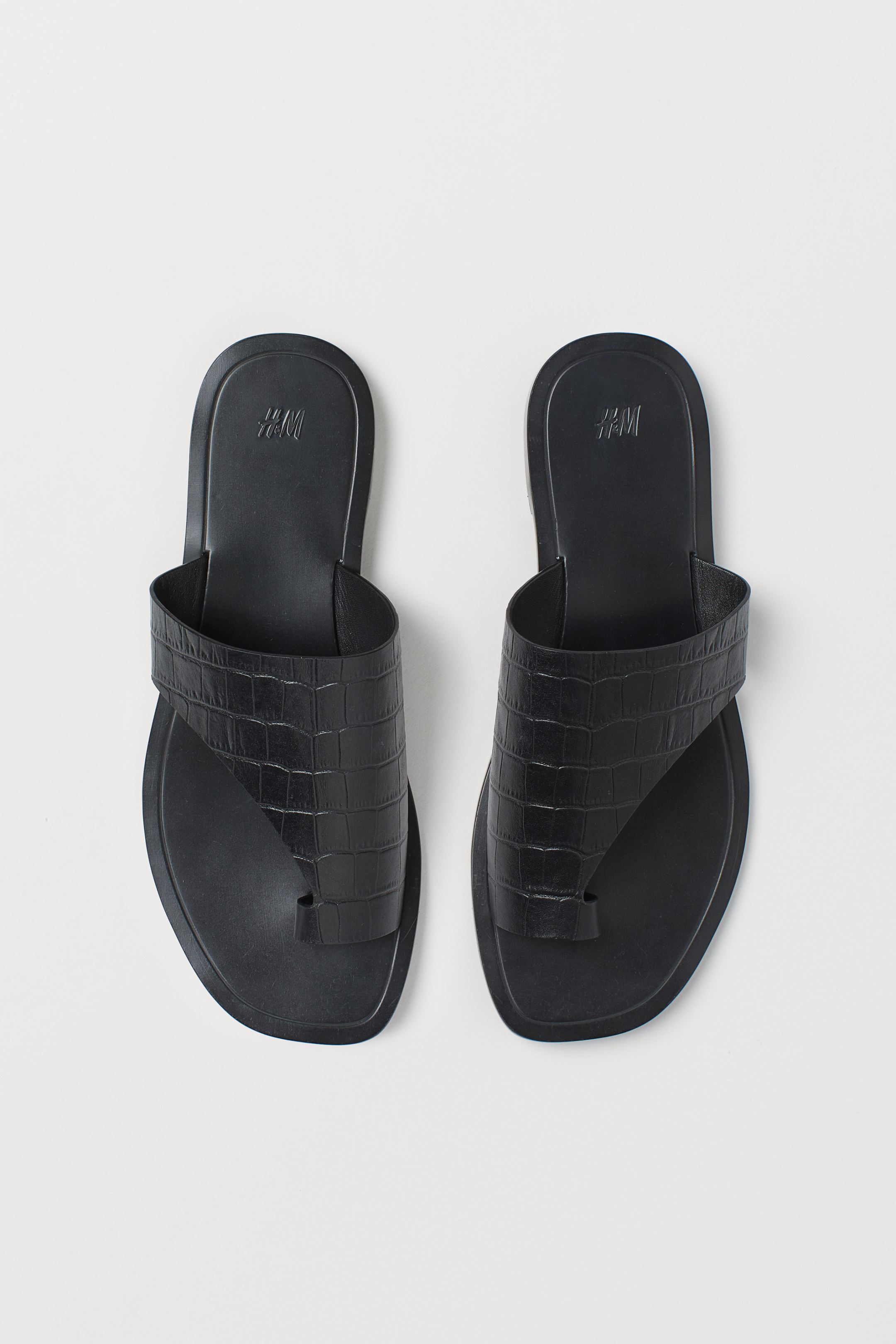 No dejes pasar una de las tendencias más vistas este verano que va a seguir arrasando en otoño: los mules de dedo. Estos negros de piel efecto cocodrilo de H&M nos han conquistado. (34,99 euros).