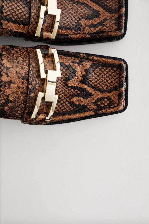 Estampado de serpiente en color marrón para estos mocasines de Zara destalonados con eslabones metalizados en la parte delantera y acabado en punta cuadrada. Cuestan 69,95 euros y están disponibles entre los números 36 y 42.