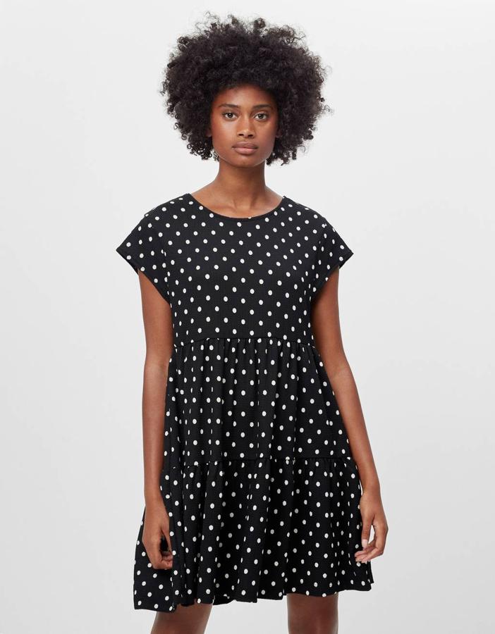 Otra de las propuestas de Bershka es este vestido negro con lunares blanco en diseño corto, con escote de pico, manga corta y vuelo en el bajo. Cuesta 15,99 euros y está disponible entre las tallas XS y L.