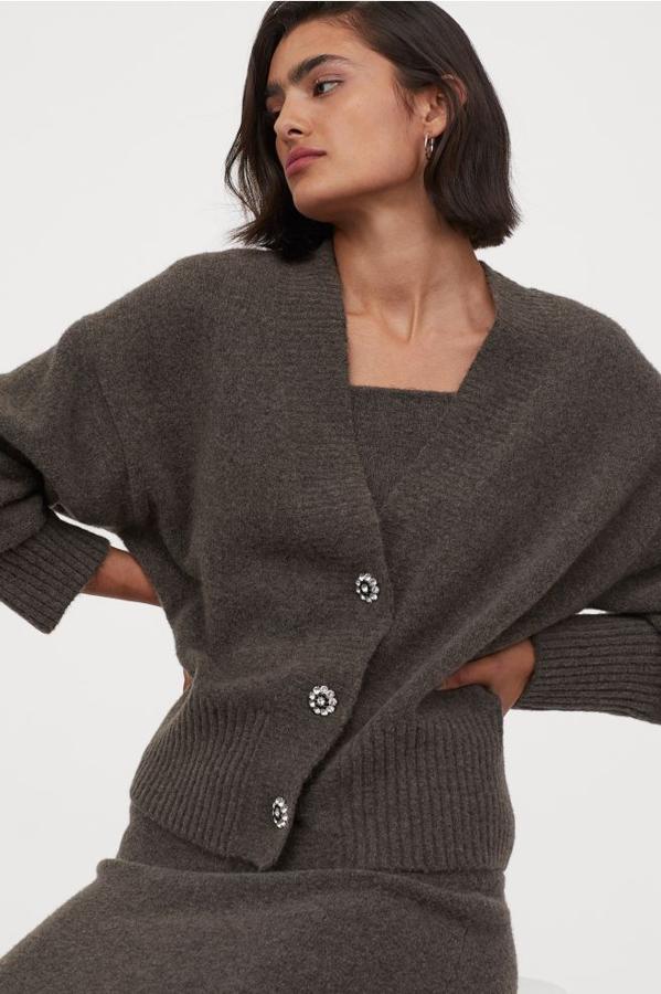 En punto suave con lana en la trama, este cárdigan de H&M en gris oscuro con corte cuadrado, hombros caídos y escote de pico pronunciado viene con botones de strass delanteros. Cuesta 29,99 euros y está disponible entre las tallas XS y XXL.