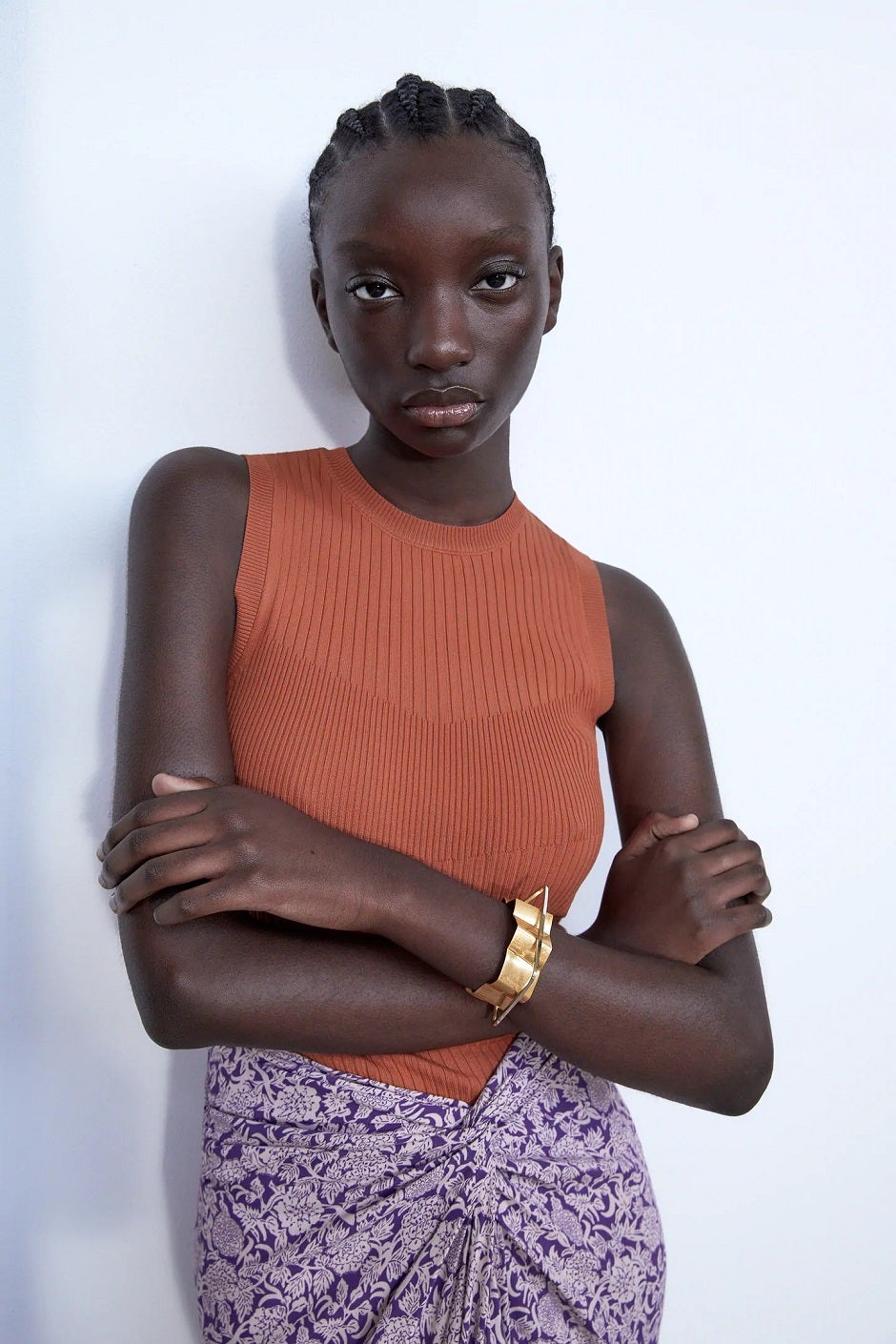 Cuello redondo y manga sisa en este top de punto en color teja de Zara. (15,95 euros).