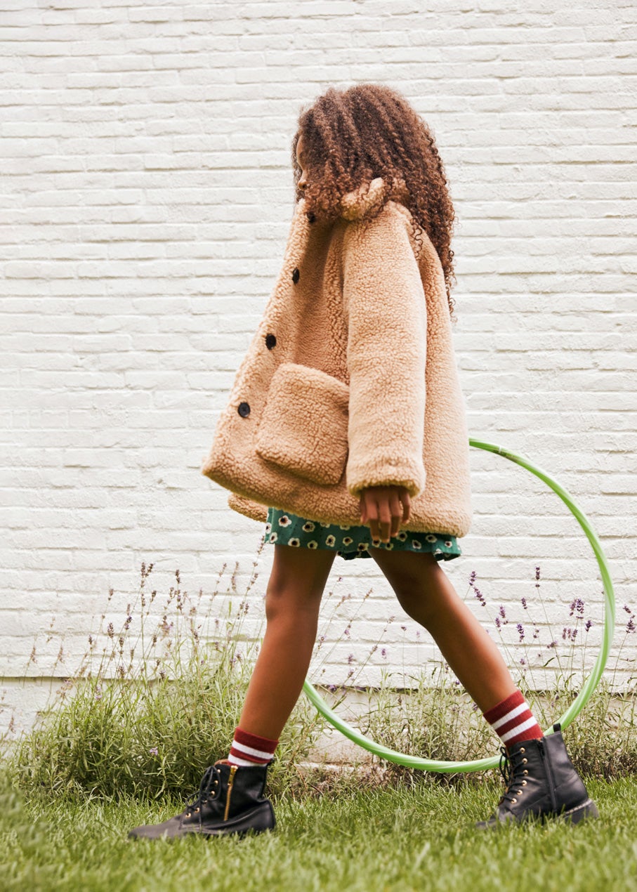 Chaquetón de borrego, falda vaporosa con estampado de flores, calcetines y botines con cremallera y cordones, todo de La Redoute Collections.