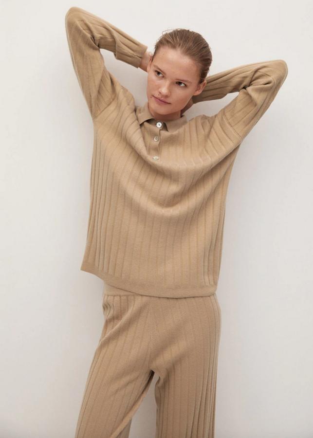 De venta exclusiva en la web de Mango, este jersey en tejido de canalé, con cuello polo con cierre de botones tiene la costura del hombro caída. En color beige, cuesta 39,99 euros y está disponible entre las tallas XS y L.