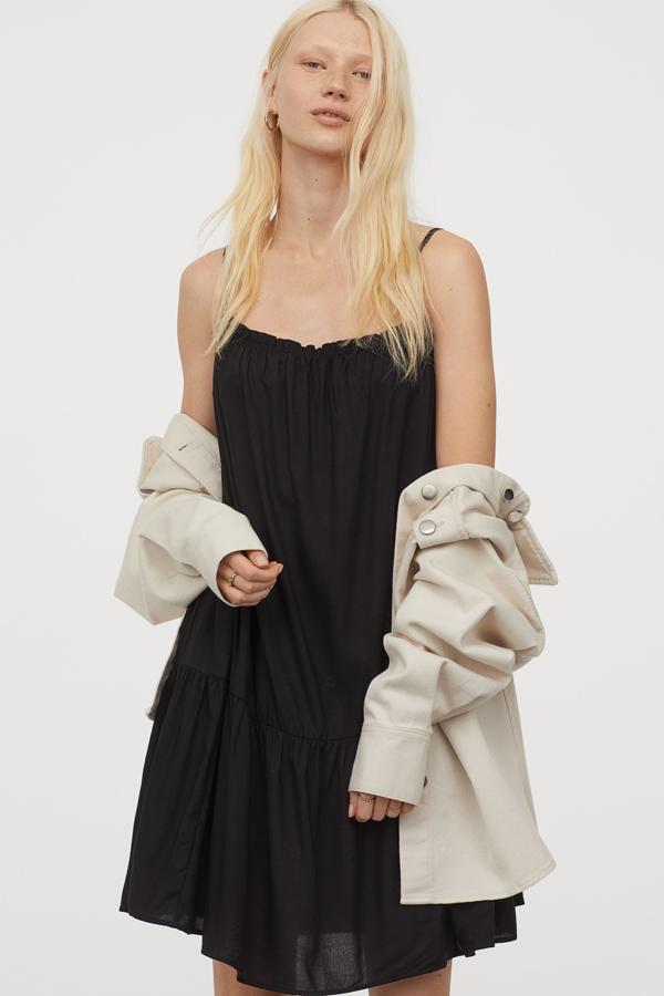 En H&M siempre nos soprenden con prendas básicas y cómodas y es lo que han hecho con este vestido negro suelto, ligero y atemporal, perfecto para llevar hasta el otoño con una cazadora vaquera (14,99 euros).