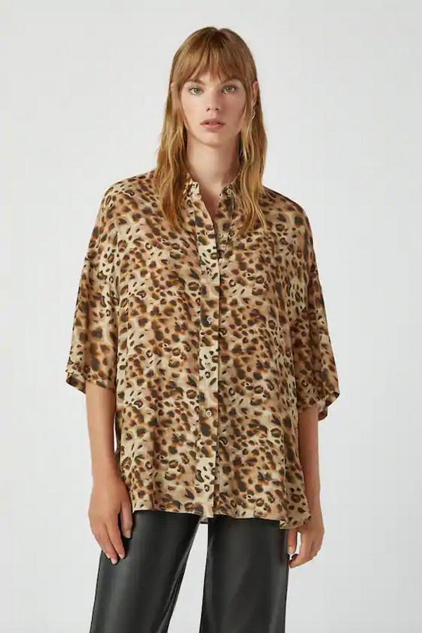 De manga corta y cuello clásico, esta camisa con estampado de leopardo de Pull&Bear está confeccionada en viscosa y tiene cierre frontal mediante botones. Con un precio de 19,99 euros, está disponible entre las tallas XS y L.