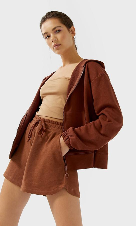 Otra de las propuestas más interesantes de Stradivarius es esta sudadera con capucha en color chocolate. Con cremallera a tono y bolsillos de canguro, tiene un precio de 17,99 euros y está disponible entre las tallas XS y XL.
