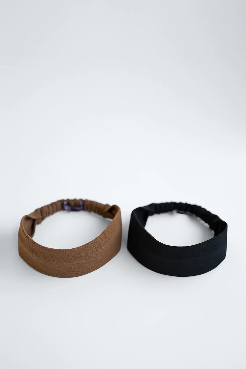 Diademas lisas básicas en color negro y marrón para combinar con cualquier estilismo y elevar el look beauty sin resultar demasiado llamativo. De Zara. (9,95 euros).