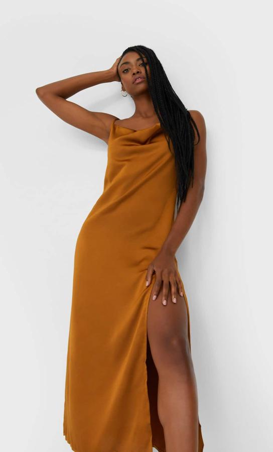 En Stradivarius encontramos este vestido lencero en satén color ocre (19.99 euros) que, además de ser súper sexy, favorece muchísimo y nos hace parecer más morenas.