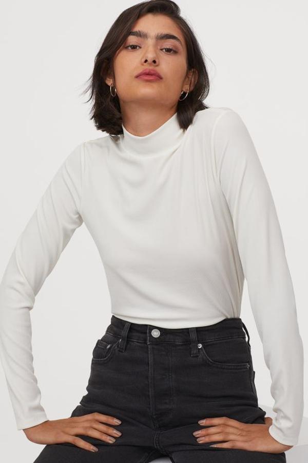 Este top blanco de mangas largas y cuello perkins de doble capa confeccionado en punto de canalé es de H&M y cuesta 9,99 euros. Podemos encontrarlo únicamente en la web, entre las tallas XS y XXL.