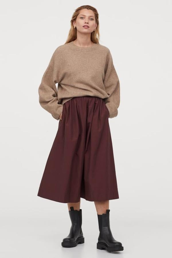 En color burdeos, con cintura paperbag alta y ribete de volantes, esta falda midi en mezcla de algodón de H&M viene con pliegues para dar volumen y bolsillos al bies. Tiene un precio de 29,99 euros y está disponible entre las tallas XS y XXL.