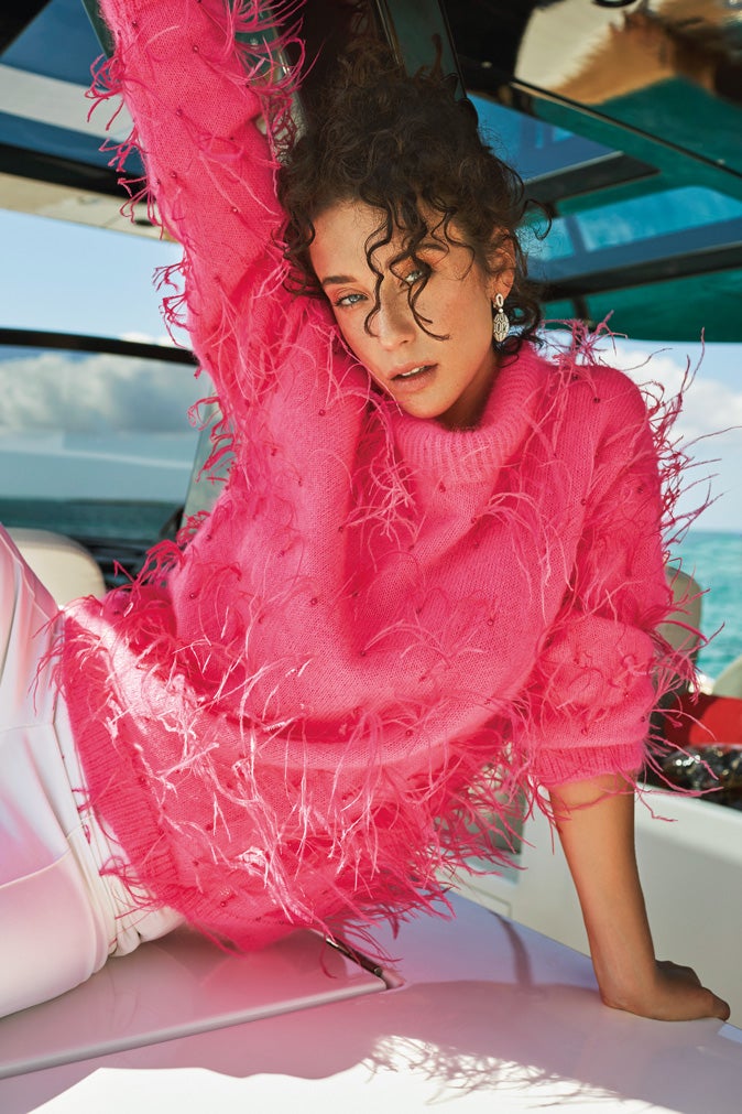 En la página siguiente, jersey de cachemir con plumas, de Pertegaz; y pantalón de Givenchy. Los pendientes Serpenti, en oro blanco y esmeraldas, son de Bvlgari.