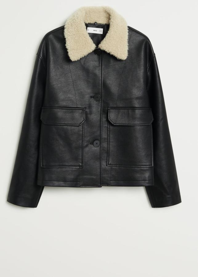 Con efecto piel en color negro esta cazadora biker con interior de pelo desmontable y bolsillos con solapa en la parte frontal es de Mango y tiene un precio de 49,99 euros.