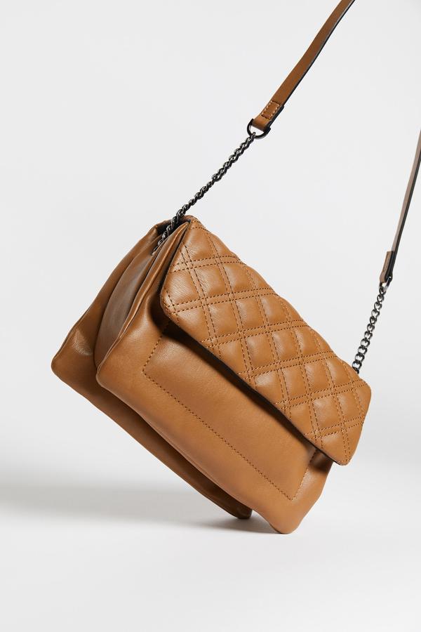 Con solapa acolchada y asa de hombro en combinación de materiales, esta bandolera de Sfera en color camel tiene un precio de 15,99 euros.