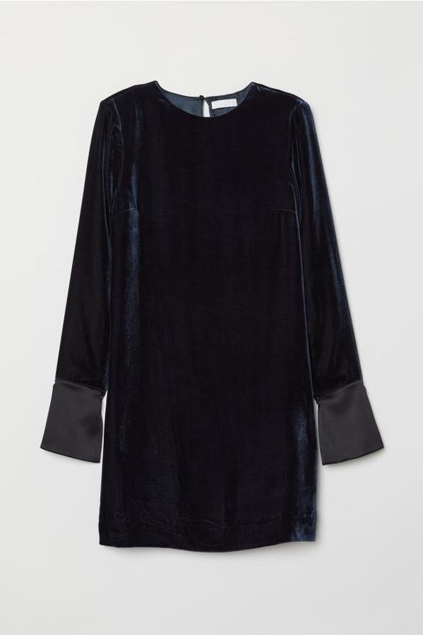En azul oscuro, con diseño corto, cuello redondo y hombreras, este vestido confeccionado en terciopelo de mezcla de será viene con mangas largas y puños anchos de satén con abertura y botón. Cuesta 99 euros y está disponible en las talla 34 y entre la 38 y la 44.