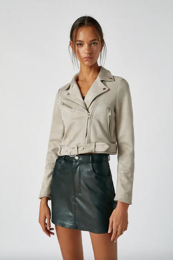 En antelina, con cierre de cremallera hasta el cuello, bolsillos laterales y uno en el pecho y cremallera frontal, esta cazadora biker en color gris de Pull&Bear tiene un precio de 25,99 euros y está disponible entre las tallas XS y XL.