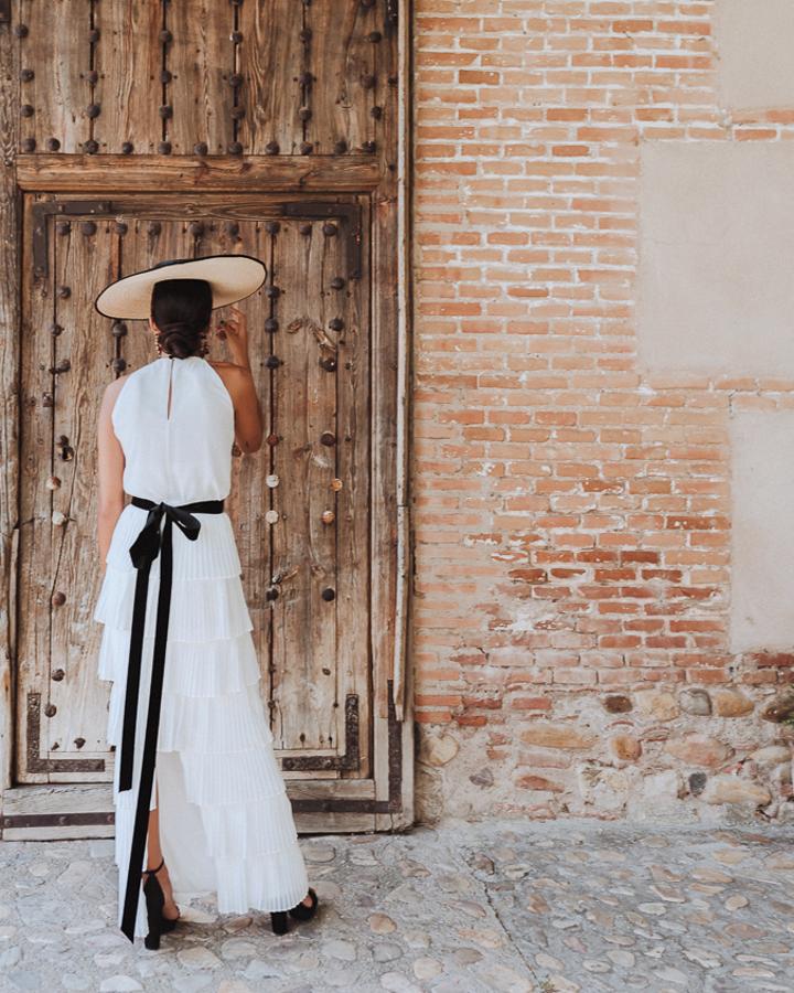 ¿Quién dijo que los looks 'black&white' no estaban pensado para las novias? Este lvestido de novia con falda de volantes plisados de María Gadea, rematado con gran lazo negro de tericopelo, pamela ribeteada y sandalias a tono nos parece sensacional.