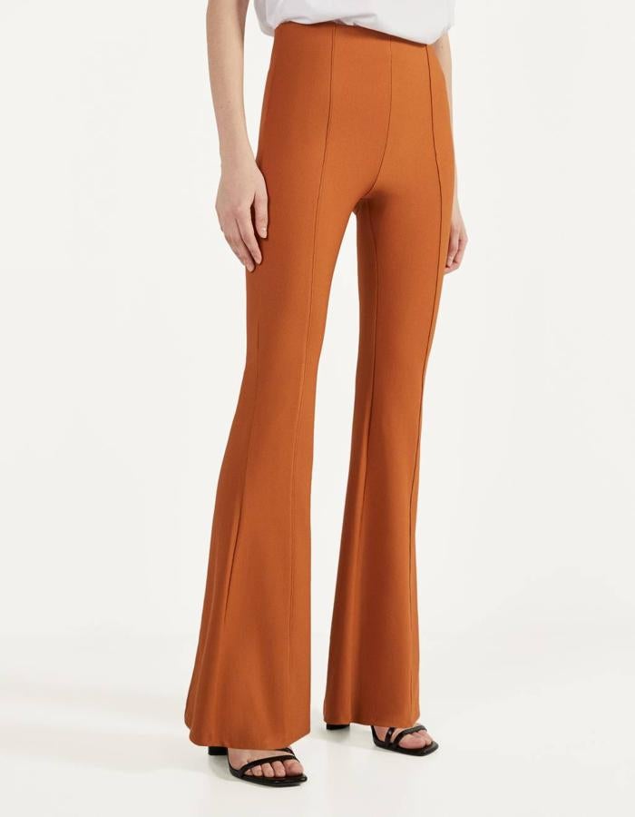 De tiro alto y cintura elástica, estos pantalones acampanados hasta la rodilla en color naranja son de Bershka y tienen un precio de 19,99 euros. Solo quedan en las tallas XS y X, aunque también se han lanzado en crudo y en negro.