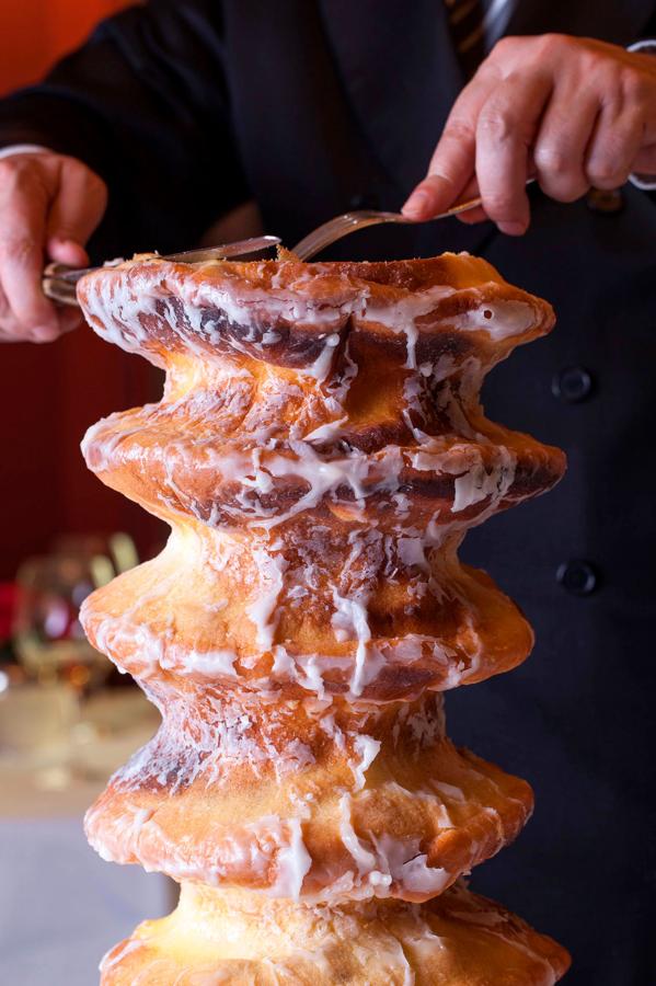 El Baumkuchen de Horcher (Calle Alfonso XII, 6, Madrid), un dulce artesanal hecho capa a capa, cubierto de chocolate caliente y acompañado de helado de chantilly.