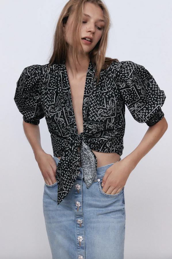 Estampado paisley sobre fondo negro para esta bonita blusa cropped de Zara con escote de pico pronunciado, manga abullonada acabada en puño elástico por debajo del codo y bajo con nudo en el frontal. Cuesta 29,95 euros y está disponible entre las tallas XS y XL.