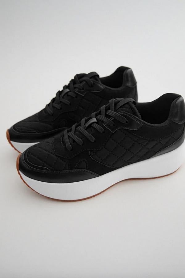 Con suela gruesa a contraste en blanco, estas zapatillas negras de Zara vienen con corte acolchado en combinación de materiales y detalle de pespuntes. Con cierre de cordones, cuestan 35,95 euros y están disponibles entre los números 35 y 42.