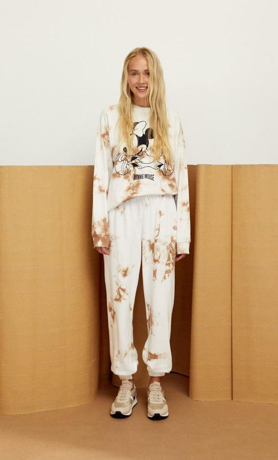 Chándal tie dye con dibujo de Minnie, en tonos blanco y camel, de la nueva colección de Stradivarius. Tanto el pantalón como la sudadera cuestan 19,99 euros.