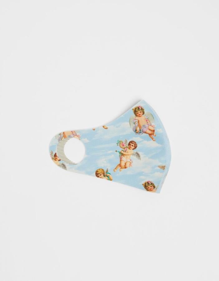 Estampado de ángeles sobre un fondo azul de nubes para esta mascarilla de Bershka reutilizable que admite 30 ciclos de lavado y tiene un precio de 6,99 euros.