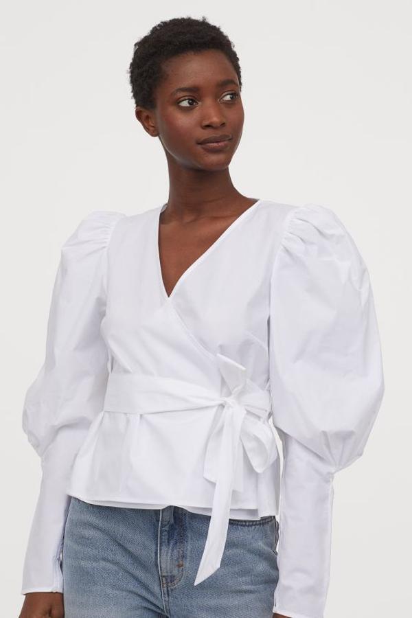 Blusa blanca cruzada con cinturón y mangas puffy, de H&M (29,99 euros).