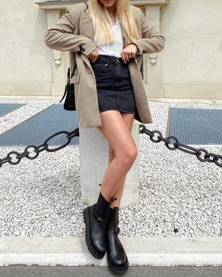 Seguro que tienes por el armario una minifalda vaquera. Un básico imprescindible que combina con todo y también con las botas chelsea, modelo que ella lleva de Ducie. La influencer añade también una blazer de cuadros dándole un toque más elegante.