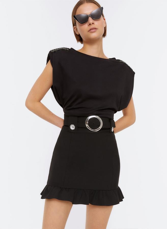 Minifalda con volante en el bajo y cintirón de hebilla circular metálica, de Uterqüe (79 €).