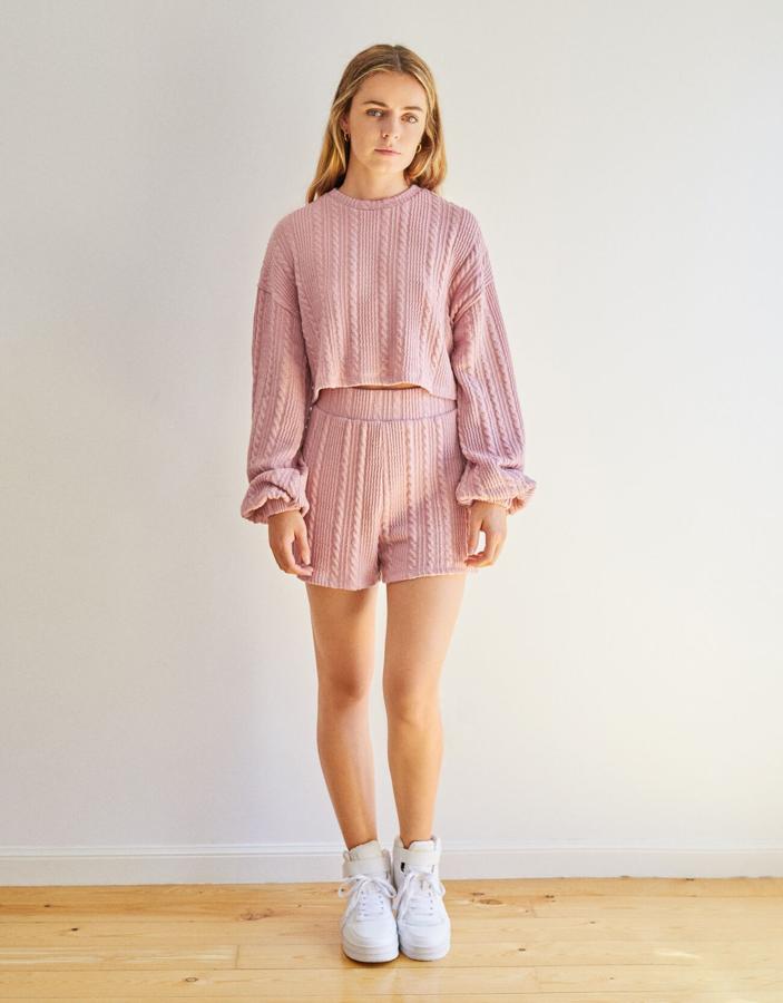 Bershka apuesta por el punto canalé con textura para este total look de sudadera 'cropped' y shorts de punto (15.99 euros) en rosa empolvado.