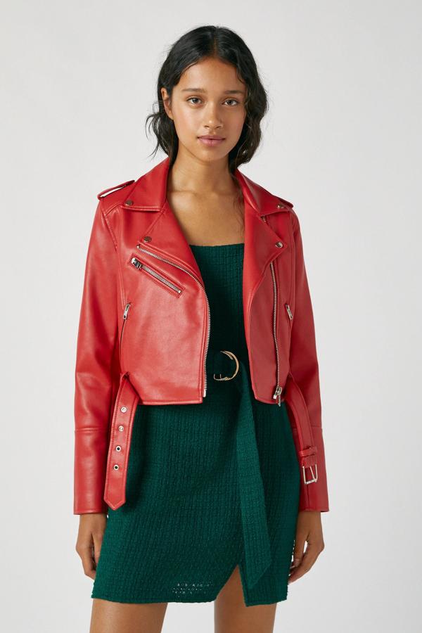 Disponible en color rojo o negro, esta cazadora biker de Pull & Bear cuenta con bolsillos y cierre de cremallera a un lado y cinturón con hebilla metalizada en el bajo. Tiene un precio de 25,99 euros.