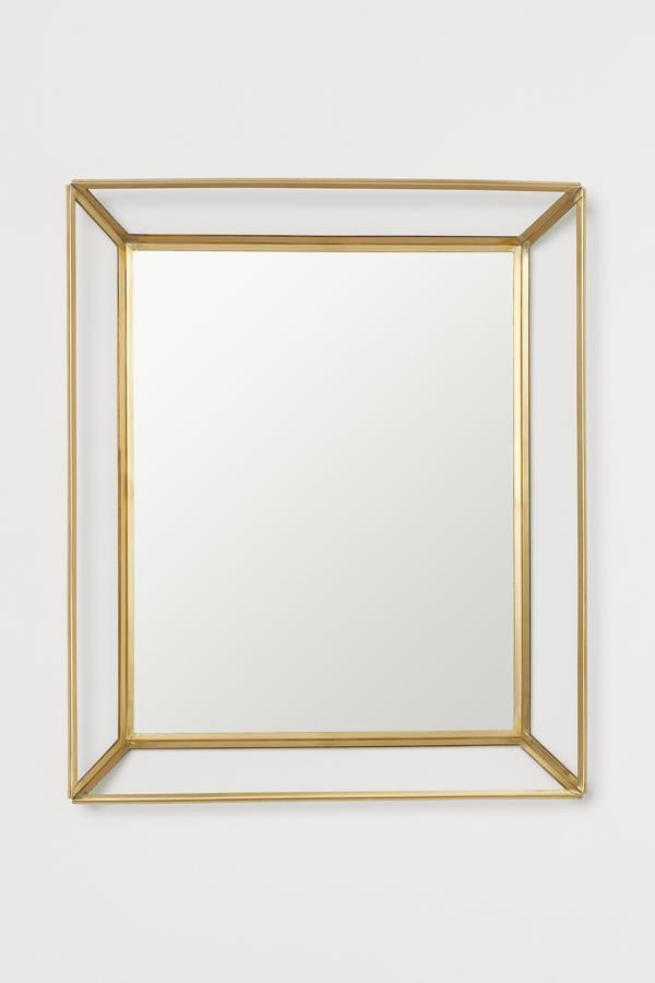 Este espejo con marco de metal dorado y vidrio transparente cuenta con colgador en la parte trasera y unas medidas de 27 centímetros de ancho y 32 de alto. Su precio es de 19,99 euros.